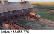 Поволжье, страда. Механизированный ток на закате. Вид с воздуха. Volga region, harvest season. Mechanized threshing floor at the sunset light. Aerial view. (2022 год). Редакционное видео, видеограф Евгений Романов / Фотобанк Лори