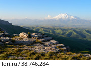 Nature mountain range. Amazing view of caucasian mountain or sleeping volcano Elbrus on Bermamyt plateau at sunrise, green fields, blue sky. Mount Elbrus landscape - highest peak of Russia or Europe. Стоковое фото, фотограф Евгений / Фотобанк Лори