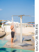 A man takes a beach shower after sea salt water. Стоковое фото, фотограф Татьяна Дворецкая / Фотобанк Лори