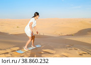 Young women sand surfing at the sand dunes of Dubai United Arab Emirates. Стоковое фото, фотограф Fokke Baarssen / Фотобанк Лори