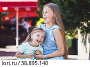 older sister tickles younger sister on the veranda in the park. Стоковое фото, фотограф Поликарпов Владимир Владимирович / Фотобанк Лори
