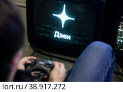 Молодой человек играет в компьютерную игру на стенде платформы Дзен фестиваля Bubble Comics Con в городе Москве, Россия (2023 год). Редакционное фото, фотограф Николай Винокуров / Фотобанк Лори