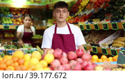 Portrait of a hardworking guy seller working in a vegetable store near the counter. Стоковое видео, видеограф Яков Филимонов / Фотобанк Лори