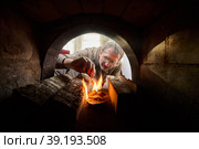 Firebox of stone wood burning stove in which fire is made to heat home. Стоковое фото, фотограф Владимир Григорьев / Фотобанк Лори