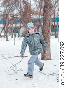A boy in a winter blue suit runs along a path in a winter park. Стоковое фото, фотограф Ярославский Максим / Фотобанк Лори