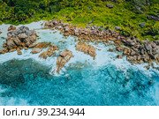 Aerial top view of beautiful tropical Anse Marron beach. Ocean waves hitting granite rocks along coastline, La Digue, Seychelles. Стоковое фото, фотограф Igor Tichonow / Фотобанк Лори
