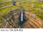 Aerial view of the Hengifoss waterfall in East Iceland. Hengifoss is the third highest waterfall in Iceland and is surrounded by basaltic strata with red layers of clay between the basaltic layers. Стоковое фото, фотограф Igor Tichonow / Фотобанк Лори