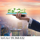 Hand holding tablet with mini ecosystem and clean energy. Стоковое фото, фотограф Elnur / Фотобанк Лори