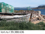 Old wooden boat on the seashore. Teriberka, Murmansk region (2022 год). Редакционное фото, фотограф Наталия Бушкевич / Фотобанк Лори