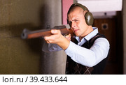 Concentrated man practicing shotgun shooting at firing range. Стоковое фото, фотограф Яков Филимонов / Фотобанк Лори