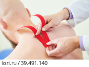 kinesiology therapeutic strip tape applying on male back for pain relief. Стоковое фото, фотограф Дмитрий Калиновский / Фотобанк Лори