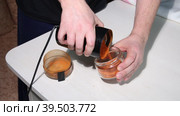 A man pours ground red pepper from a coffee grinder into a jar. Grinding hot pepper. Medium plan. Стоковое видео, видеограф Vadzim Yakubovich / Фотобанк Лори