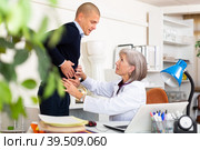 Man complaining about stomach ache to mature woman physician. Стоковое фото, фотограф Яков Филимонов / Фотобанк Лори