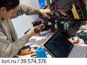 Участники соревнований собирает робота на региональном этапе чемпионата по робототехнике Robotics championship среди участников из Москвы и Московской области на ВДНХ в городе Москве, Россия (2023 год). Редакционное фото, фотограф Николай Винокуров / Фотобанк Лори