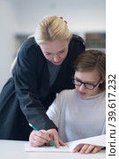 female teacher helping students on class. Стоковое фото, фотограф Benis Arapovic / PantherMedia / Фотобанк Лори