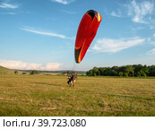 Мотопараплан с пилотом и пассажиром совершает взлёт. A paramotor with a pilot and a passenger takes off. (2022 год). Редакционное фото, фотограф Евгений Романов / Фотобанк Лори