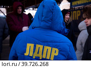 Мужчина в синей куртке с надписью на спине ЛДПР на акции партии в городе Москве, Россия (2023 год). Редакционное фото, фотограф Николай Винокуров / Фотобанк Лори