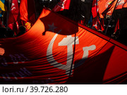 Развернутая копия Знамени Победы во время праздничного митинга партии КПРФ ко Дню защитника Отечества на площади Революции в центре города Москвы, Россия (2023 год). Редакционное фото, фотограф Николай Винокуров / Фотобанк Лори