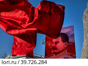Сторонники партии КПРФ держат флаг СССР и портрет Иосифа Виссарионовича Сталина во время праздничного митинга ко Дню защитника Отечества на площади Революции в центре города Москвы, Россия (2023 год). Редакционное фото, фотограф Николай Винокуров / Фотобанк Лори