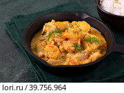 Fish curry with codfish, pollack and shrimps with coconut milk served in cast iron pan. Стоковое фото, фотограф Оксана Чаюн / Фотобанк Лори