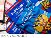 Федеральный закон Российской Федерации "О бухгалтерском учете" и Налоговый кодекс лежит на столе у бухгалтера (2023 год). Редакционное фото, фотограф Николай Винокуров / Фотобанк Лори
