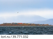 Вид с моря на чукотское село Янракыннот, расположенное на берегу пролива Сенявина Берингова моря, в окружении тундры и гор. Осенняя дождливая погода. Чукотка, Россия. Стоковое фото, фотограф Андрей Степанов / Фотобанк Лори