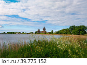Kizhi Island, Karelia, Russia. The view from the water of a unique ancient architectural ensemble of traditional wooden folk architecture. UNESCO World Heritage Site in Russia.Summer sunny day. (2015 год). Стоковое фото, фотограф Оксана Медведева / Фотобанк Лори
