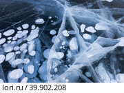 Natural winter icy texture with white bubbles and cracks in blue ice of frozen Baikal Lake in cold February day. Abstract bright textured background, mock up, flat lay, close-up. Стоковое фото, фотограф Виктория Катьянова / Фотобанк Лори