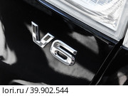 Shiny chrome V6 mark on black back car hood. High performance engine. Стоковое фото, фотограф EugeneSergeev / Фотобанк Лори