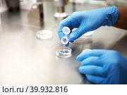 Hands of a scientist in the laboratory with a test tube and a microscope. The invention of the vaccine, a doctor in the clinic of artificial insemination IVF. Tests, fertilization of the egg. Стоковое фото, фотограф Ольга Симонова / Фотобанк Лори