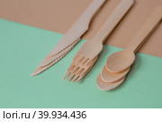 Экологически чистая одноразовая кухонная утварь на бежево-зеленом фоне. Деревянные вилки, ложки и ножи. Экология, концепция нулевых отходов. Стоковое фото, фотограф Photojuli / Фотобанк Лори