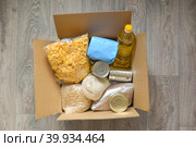 Box of products in the center: oil, rice, pasta, canned food, cornflakes. food help to schoolchildren. top view. horizontal oriented. Стоковое фото, фотограф Тамара Сахарова / Фотобанк Лори