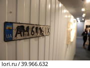 Фотовыставка Владимира Соловьева  "За лентой" на Мосфильме, табличка номерной знак автомобиля (2023 год). Редакционное фото, фотограф Дмитрий Неумоин / Фотобанк Лори