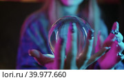 A young woman shows tricks with a crystal ball in her hands. Стоковое видео, видеограф Константин Шишкин / Фотобанк Лори