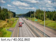 Автомобильное движение на трассе М-11 Москва - Санкт-Петербург летним днем. Участок автодороги в районе города Валдай и реки Валдайка (2019 год). Редакционное фото, фотограф Pukhov K / Фотобанк Лори
