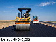 Kyzylorda province, Kazakhstan, April 29, 2012: Construction of West Europe-West China road. Caterpillar asphalt compactor on new asphalt. Стоковое фото, фотограф Alexey Rezvykh / Фотобанк Лори