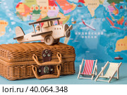 Туризм. Модель старинного самолета, шезлонги и чемодан на фоне карты мира. Концепция путешествий, приключений и открытий. (2023 год). Стоковое фото, фотограф Photojuli / Фотобанк Лори