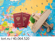 Туризм. Модель старинного самолета air и российский паспорт на фоне карты мира. Концепция путешествий, приключений и открытий. (2023 год). Стоковое фото, фотограф Photojuli / Фотобанк Лори