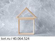 Модель деревянного дома на сером фоне. Строительство, покупка, аренда и продажа жилья. Семья и ипотека. Стоковое фото, фотограф Photojuli / Фотобанк Лори