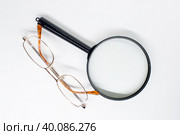 Очки в оправе и увеличительное стекло на белом фоне. Стоковое фото, фотограф Жигалов Евгений Павлович / Фотобанк Лори