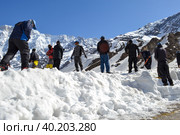 Laborer opening the snow-covered Kedarnath temple route. Стоковое фото, фотограф Devendra Rawat / Фотобанк Лори