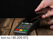 Payment terminal .Payment by mobile phone through a terminal in the store. Стоковое фото, фотограф Александр Поташев / Фотобанк Лори