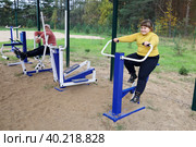 Две пухлые девочки хотят тренироваться на уличных тренажерах. Стоковое фото, фотограф Vladimir Vikhrov / Фотобанк Лори