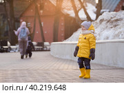 Портрет маленького ребенка 4 лет в желтых резиновых сапогах и куртке. Малыш гуляет в парке весной. Фотография весенних и осенних праздников. Стоковое фото, фотограф Photojuli / Фотобанк Лори