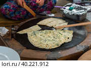 Turkish woman prepares Gozleme - traditional dish in the form of flatbread stuffed with greens and cheese, wrapped inside. Baked in a pan called a saj. Selective focus (2019 год). Стоковое фото, фотограф Виктория Панченко / Фотобанк Лори
