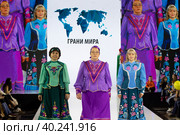 Женщины демонстрируют казачий национальный костюм на подиуме в рамках шоу "Грани Мира" на фестивале детской моды Kids Fashion Week в "Центральном детском магазине на Лубянке" (ЦДМ) в Москве, Россия (2023 год). Редакционное фото, фотограф Николай Винокуров / Фотобанк Лори