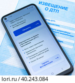 Смартфон с приложением ГосуслугиАвто на бланке извещения о ДТП. Стоковое фото, фотограф Анна Аникова / Фотобанк Лори