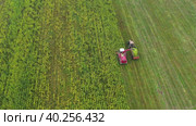 High Angle follow combine harvester removes crop from green field into tractor. Стоковое видео, видеограф Кирилл Трифонов / Фотобанк Лори