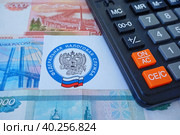 Письмо с эмблемой Федеральной налоговой службы, калькулятор и российские деньги (2023 год). Редакционное фото, фотограф Цибаев Алексей / Фотобанк Лори