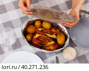 Whole chicken baked with potatoes in tinfoil deep bowl. Стоковое фото, фотограф Яков Филимонов / Фотобанк Лори